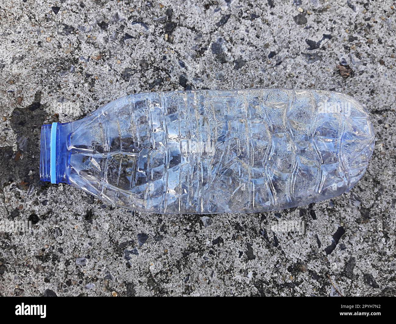 A plastic bottle of drinking water littering on the street ground Stock Photo