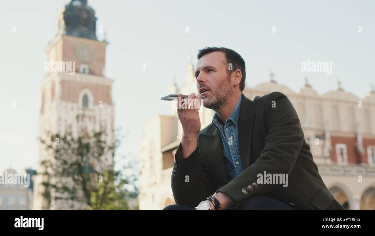 Man sends voice message on old town background Stock Photo