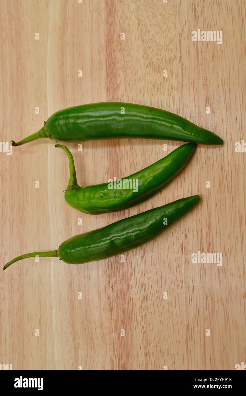 Green cayenne chilies against a plain background Stock Photo