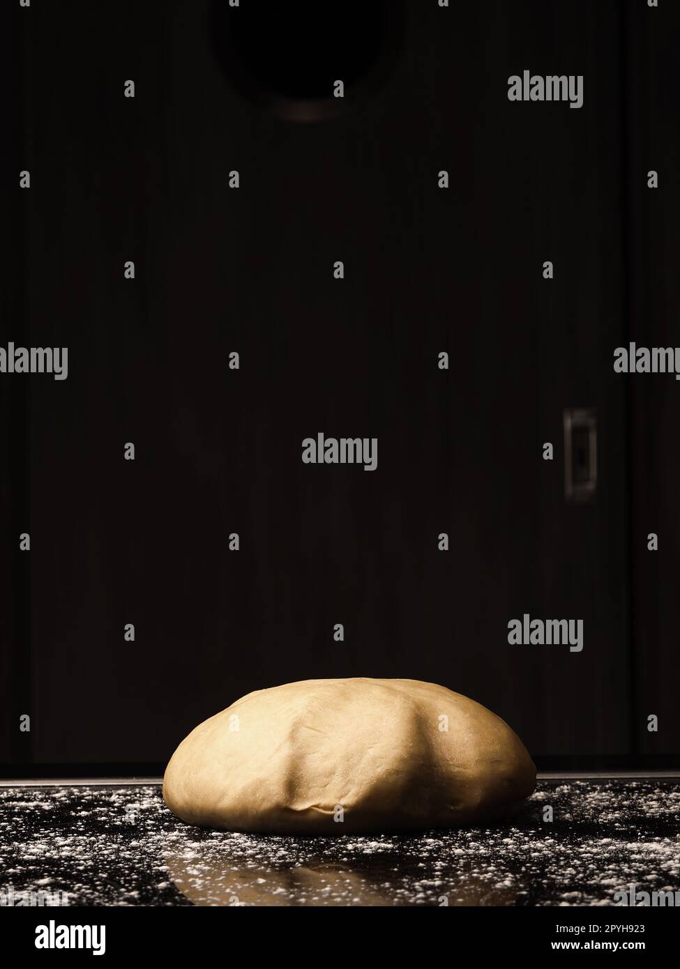 Floured organic yeast dough lies on the kitchen work surface Stock