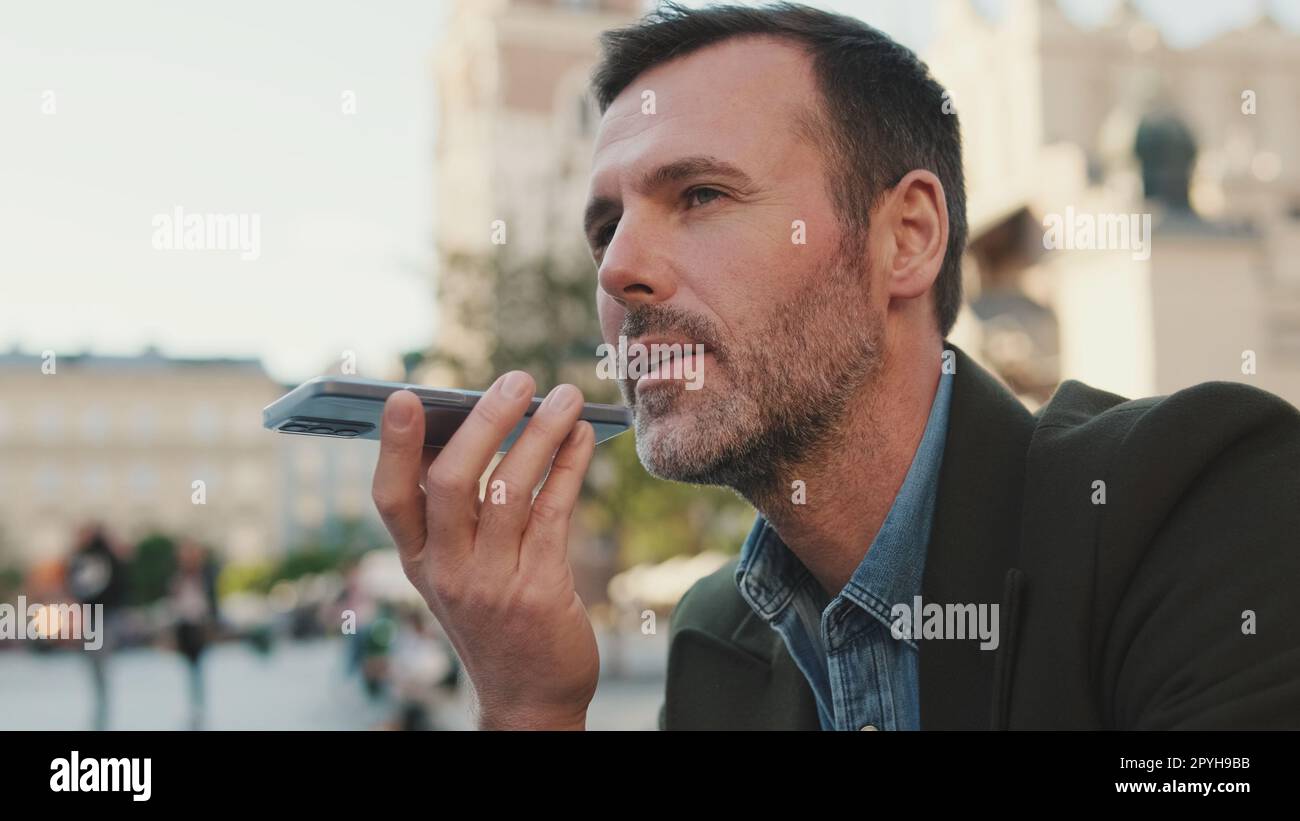 Man sends voice message on old town background Stock Photo