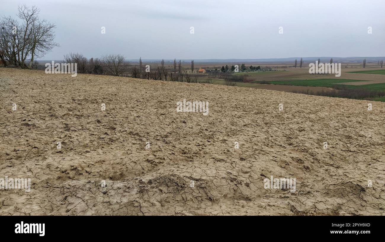 Freshly plowed field. Arable land with fertile soil for planting wheat. Rural landscape in Serbia, Balkans, namely Fruska Gora from Sremska Mitrovica. Furrows and pits. Preparatory agricultural work Stock Photo