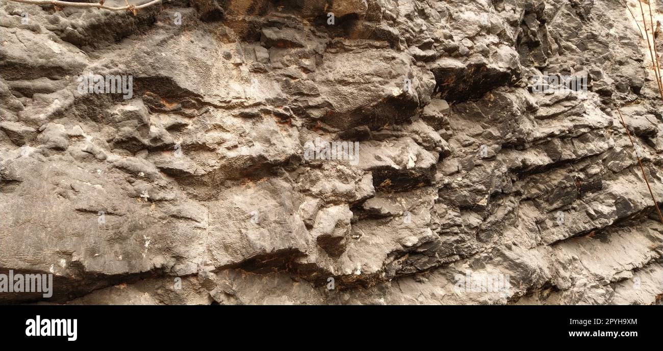 stone rock closeup in Sarajevo, Bosnia and Herzegovina. Ancient frozen lava. Layers and strata of rocks. Mountain after a guided explosion to lay the road. Texture of the stone. Gray and beige color Stock Photo