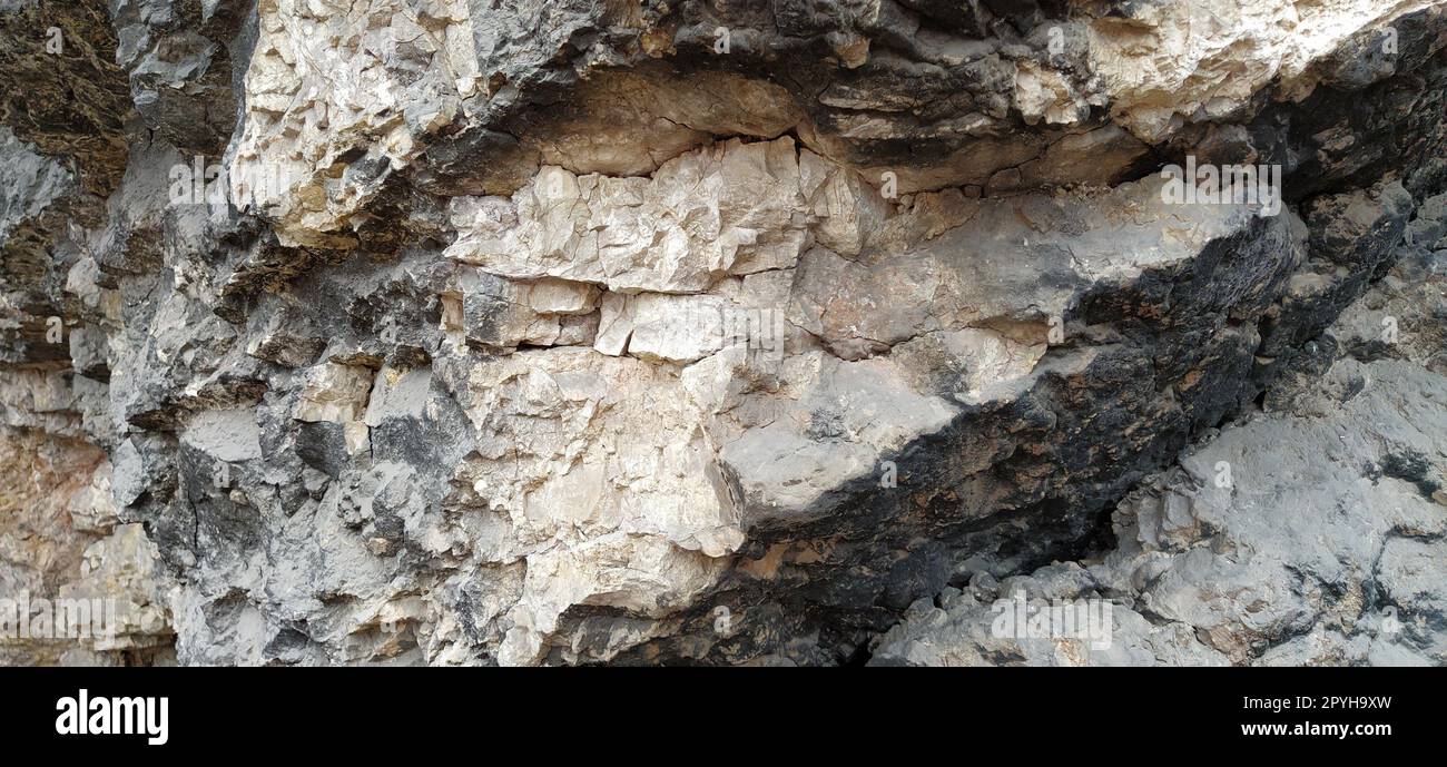 stone rock closeup in Sarajevo, Bosnia and Herzegovina. Ancient frozen lava. Layers and strata of rocks. Mountain after a guided explosion to lay the road. Texture of the stone. Gray and beige colors Stock Photo