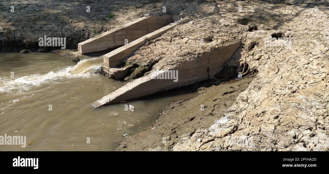 A large city drain drains sewage into a canal that flows into the river. Ecological problem. The