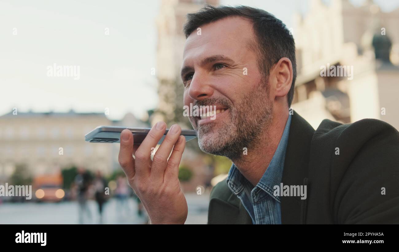 Man sends voice message on old town background Stock Photo