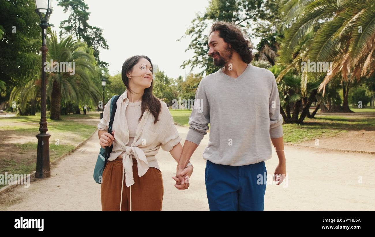 Couple in love walking in the park holding hands Stock Photo - Alamy