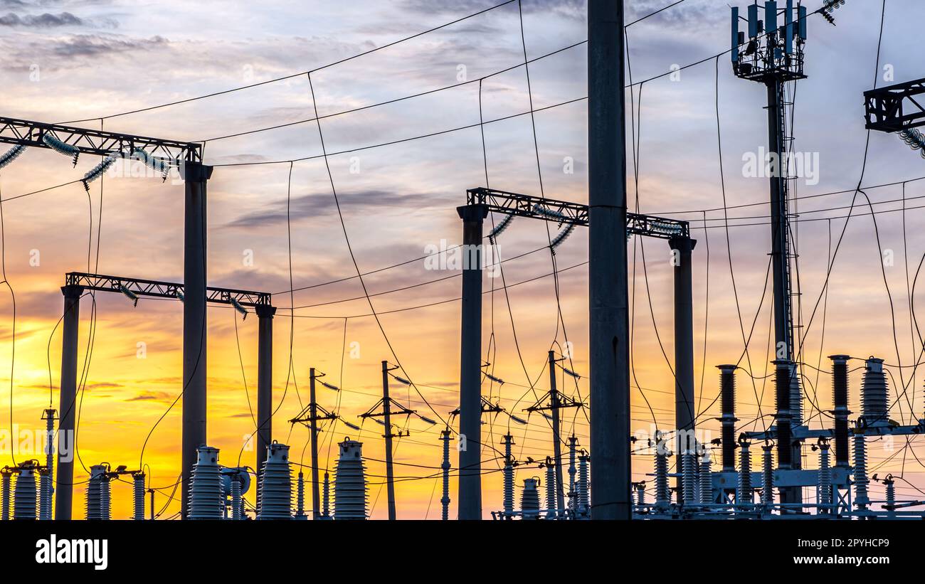 Production of fuel and electricity.Electrical networks with wires and transformers at sunset.Power transmission lines and from the power plant.Power lines with wires under voltage and electric current Stock Photo