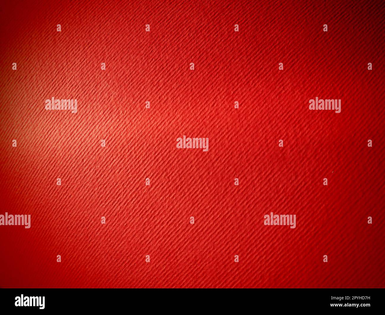 Abstract red background with texture. Close-up of paper surface with light and color gradient. Side lighting. Bright crimson backdrop Stock Photo