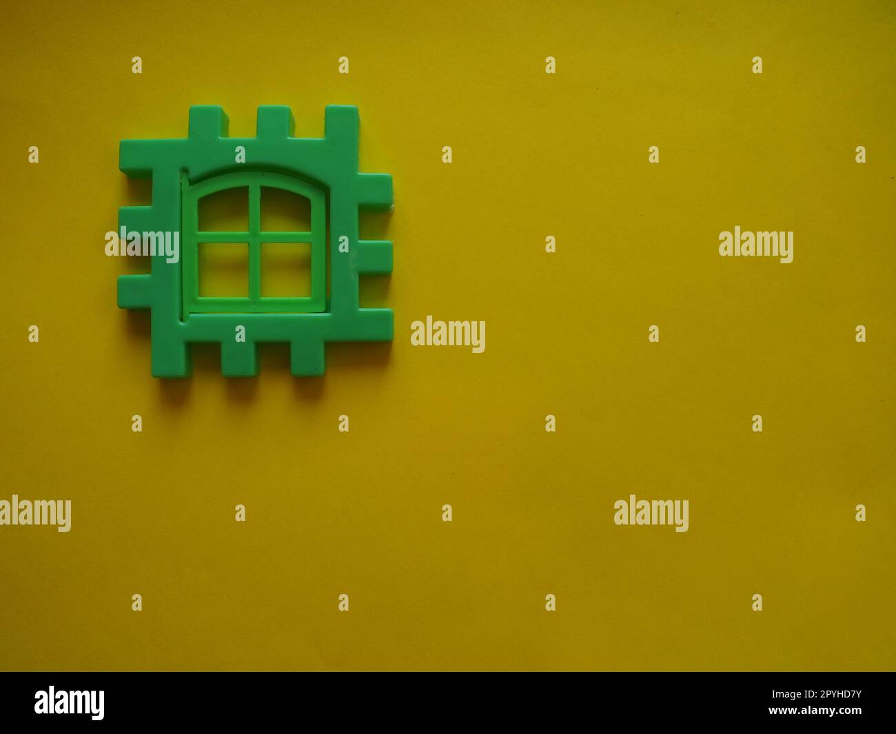 green plastic kids constructor on yellow background. Flat lay top view copy space. Plastic building blocks background. Developing toys, game Stock Photo