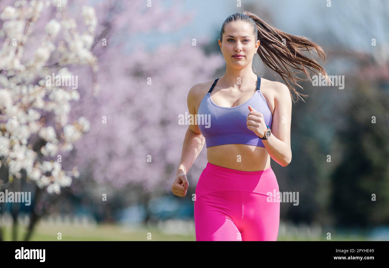 Sportive girl running in park on spring day Stock Photo