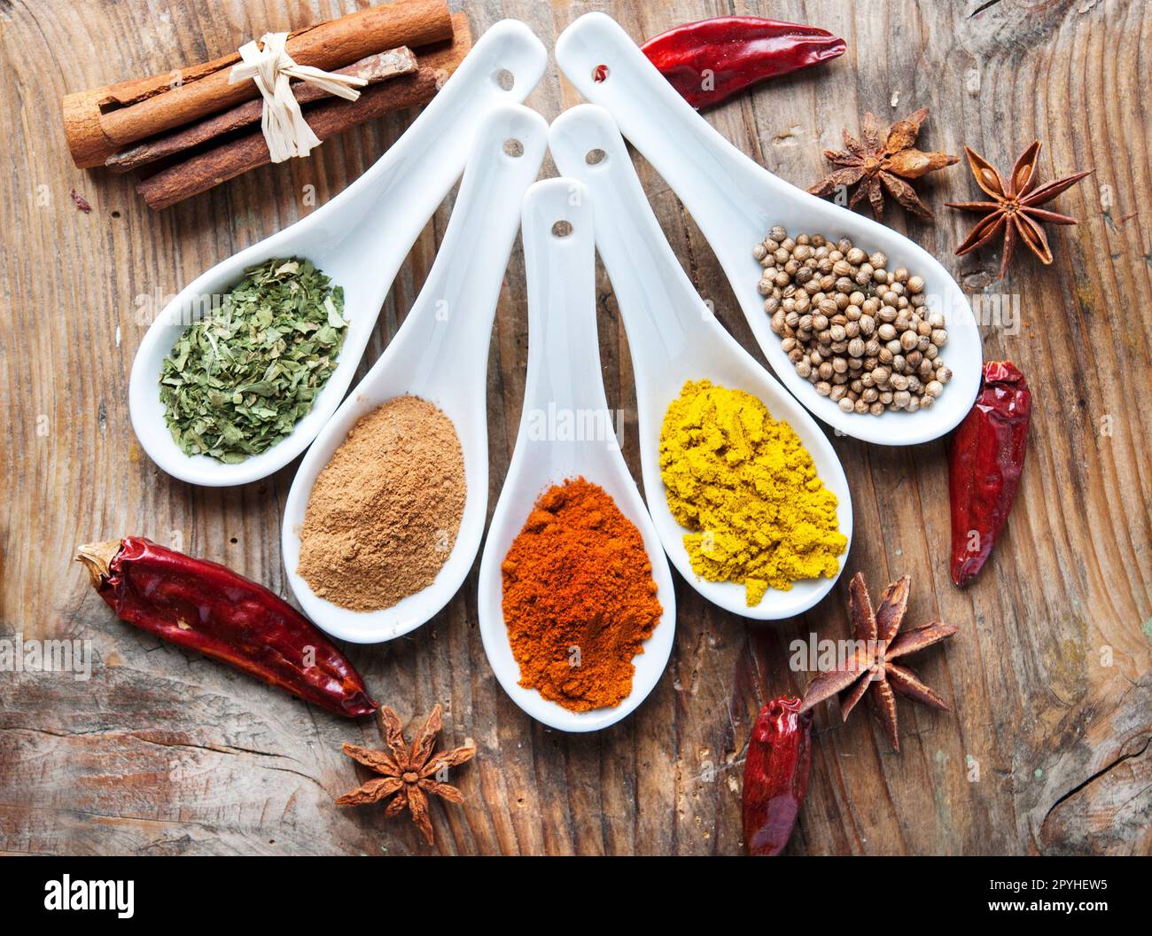 Top view on mixed dry colorful spices on wooden rustic table. Stock Photo