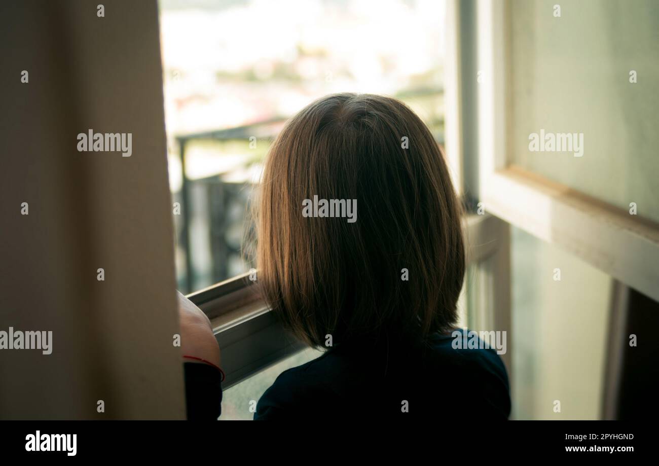Little girl looking out the window Stock Photo - Alamy