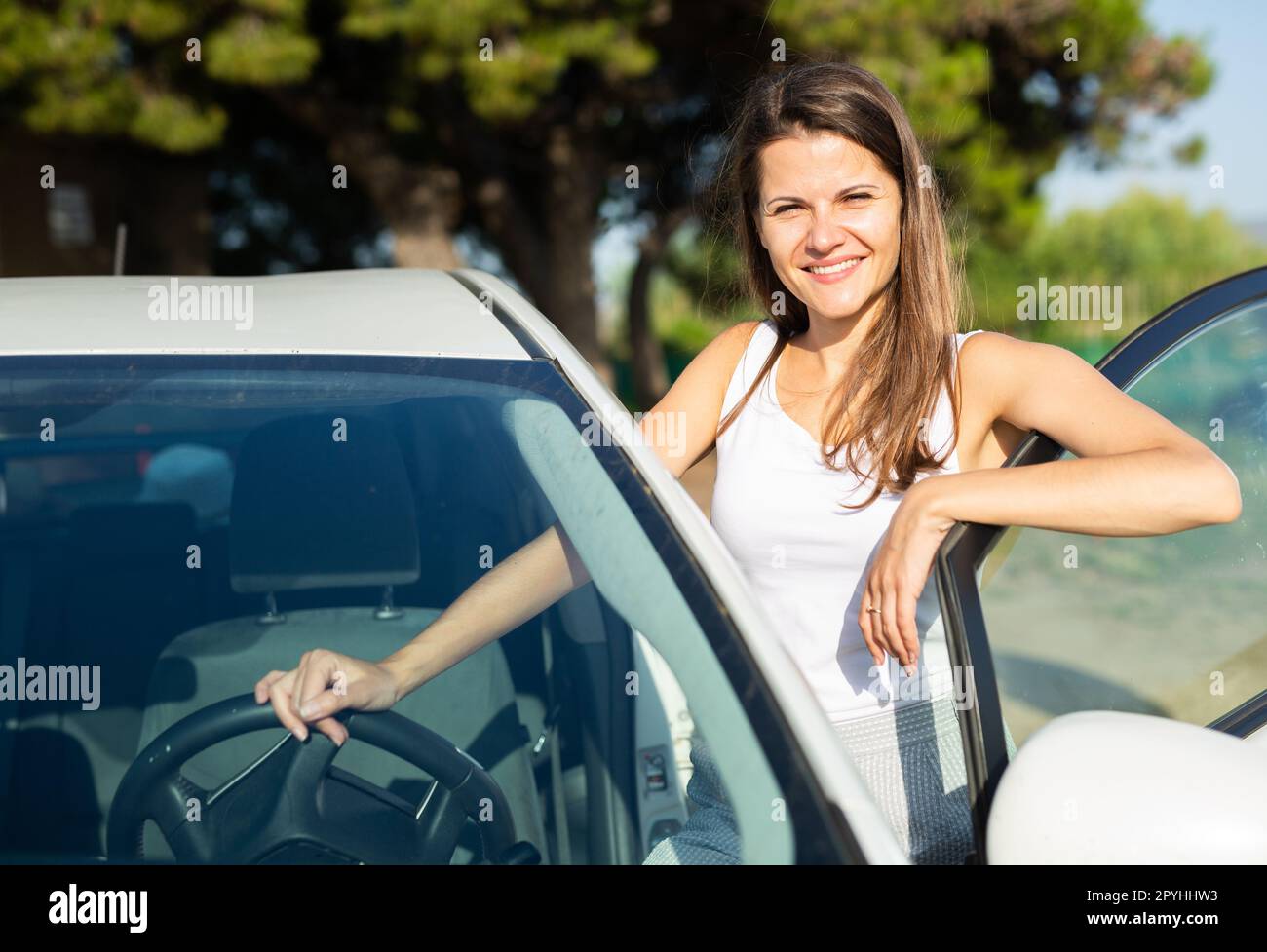 Happy Smiling Woman Posing Next To New Car On The Street Stock Photo happy-smiling-woman-posing-next-to-new-car-on-the-street-stock-photo