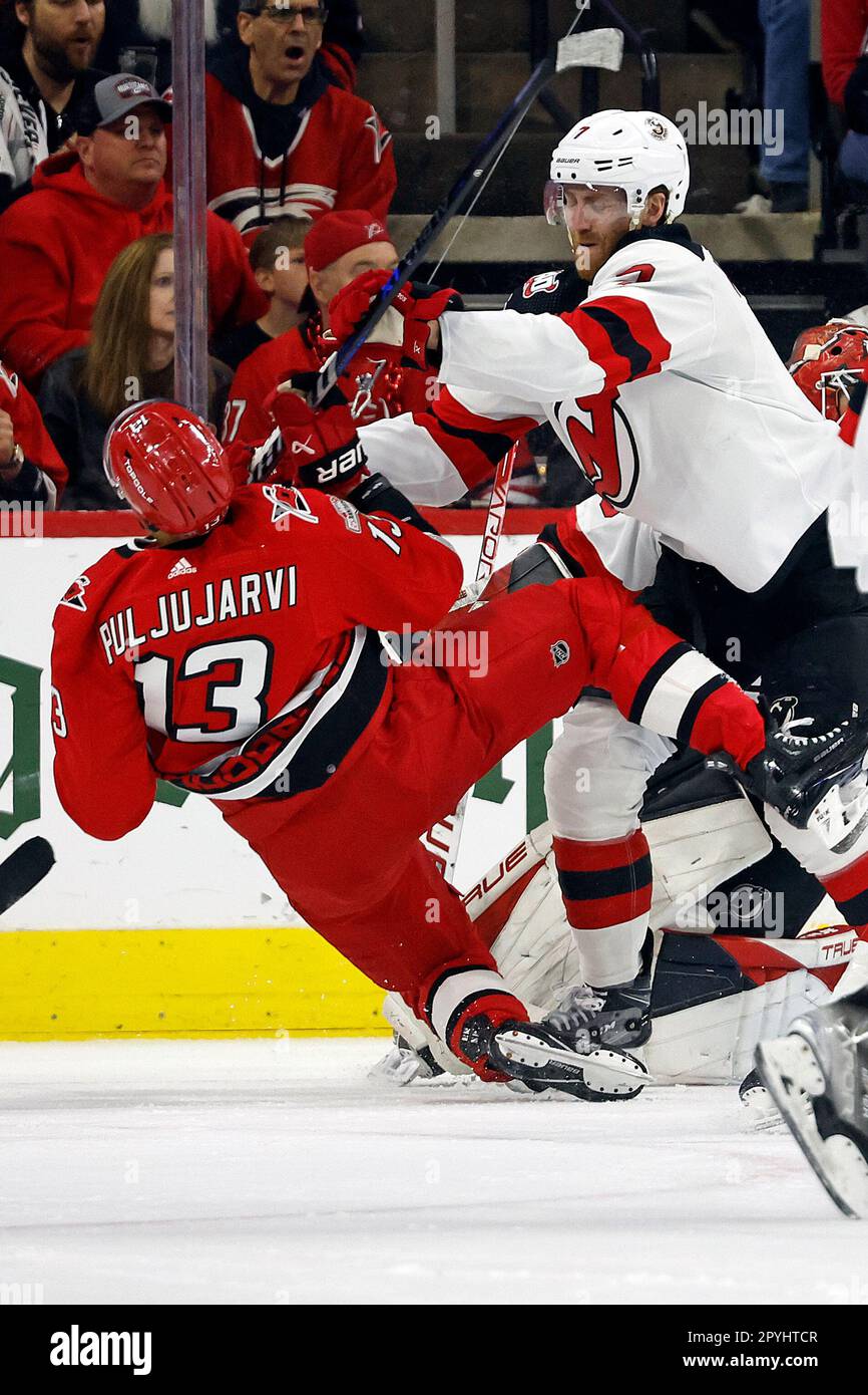 New Jersey Devils' Dougie Hamilton (7) cross-checks Carolina Hurricanes'  Jesse Puljujarvi (13) during the first period of Game 1 of an NHL hockey  Stanley Cup second-round playoff series in Raleigh, N.C., Wednesday,