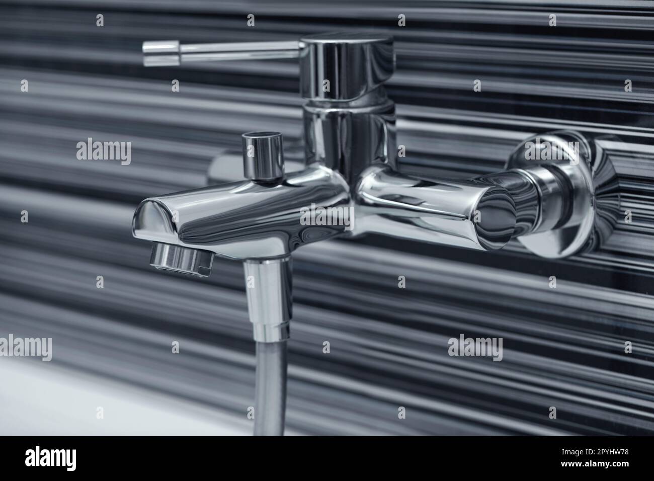 Shiny bath water tap installed on black and white wall Stock Photo Alamy