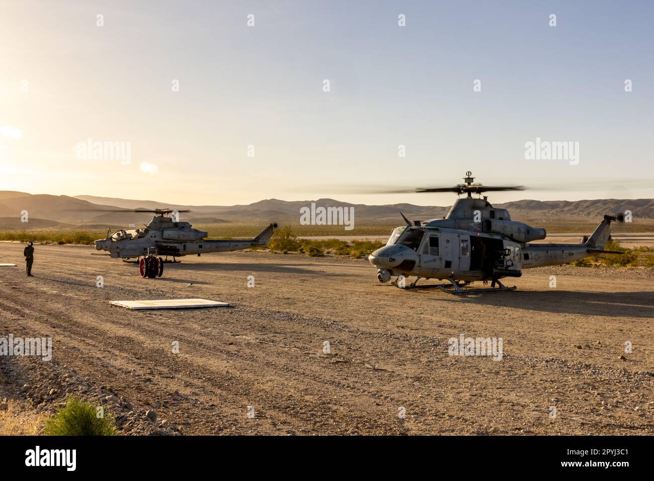 A U.S. Marine Corps UH-1Y Venom and an AH-1Z Viper, with Marine Light Attack Helicopter Squadron (HMLA) 367, Marine Aircraft Group 39, 3rd Marine Aircraft Wing, power up for a training mission during National Training Center Rotation 23-07 at Fort Irwin, California, April 27, 2023. During the exercise, HMLA-367 is supporting the 75th Ranger Regiment and 160th Special Operations Aviation Regiment (SOAR) as the sole rotary-wing fire support element, enhancing joint planning and execution of long-range assault force escort, deep and close air support, and direct-action raids. (U.S. Marine Corps p Stock Photo