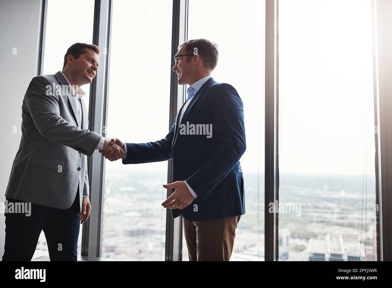 Let me be the first to congratulate you. Low angle shot of two corporate businessmen shaking hands during a meeting in the boardroom. Stock Photo