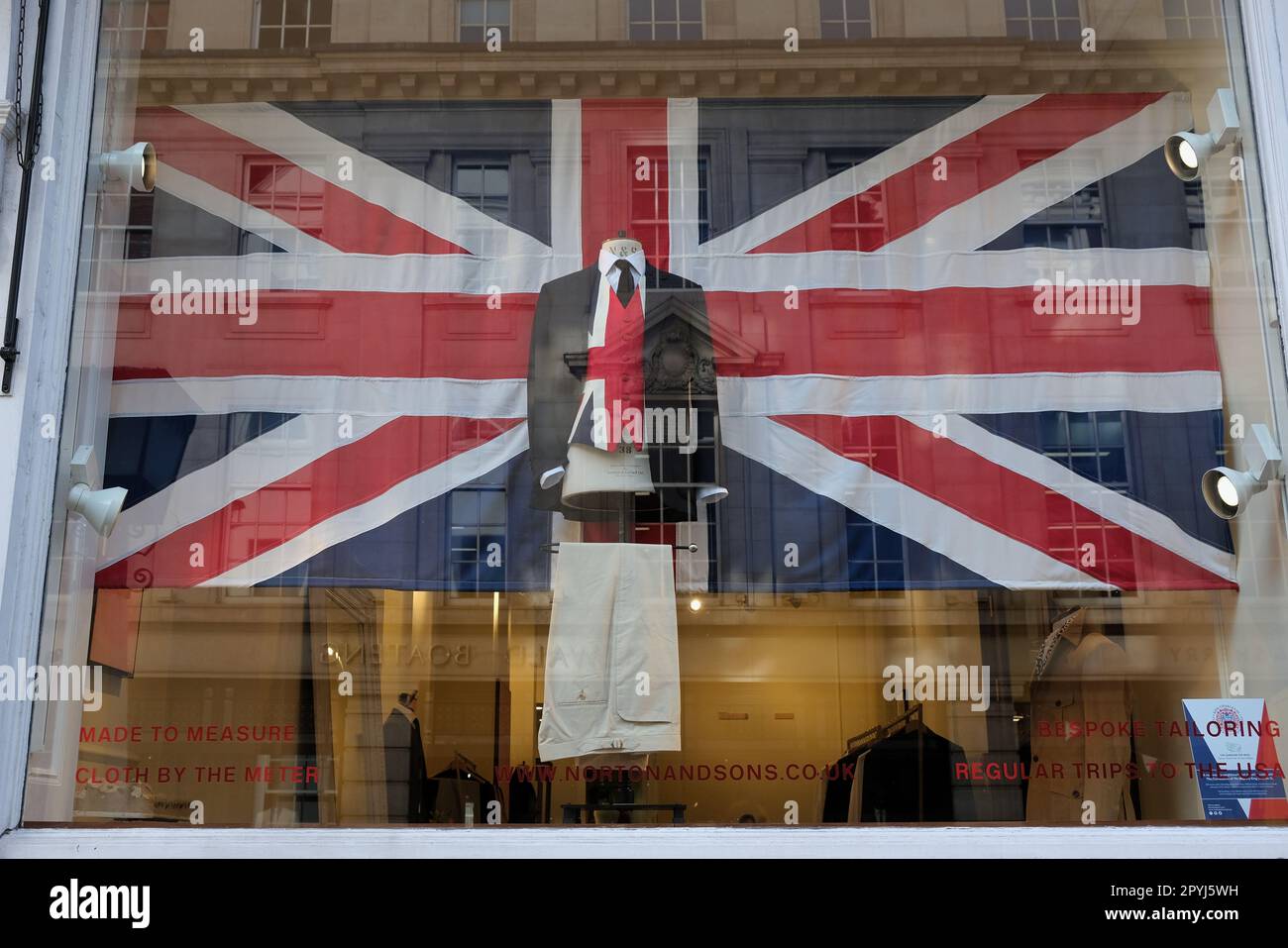 London, UK. A Union flag and men's ensemble in a tailors' window display in Saville Row for the run up to the King's coronation. Stock Photo