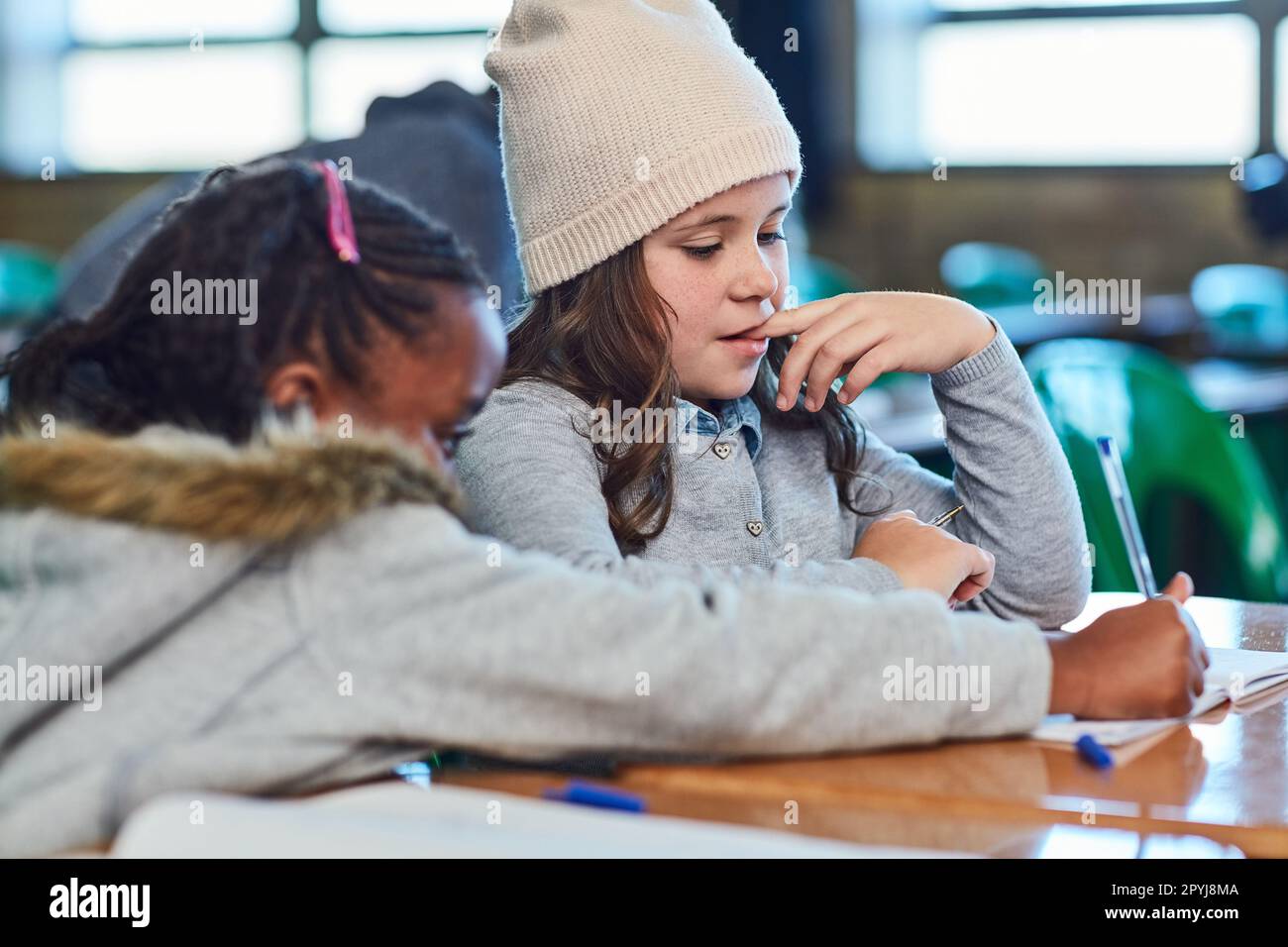 Helping each other to complete the lesson. elementary school girls ...