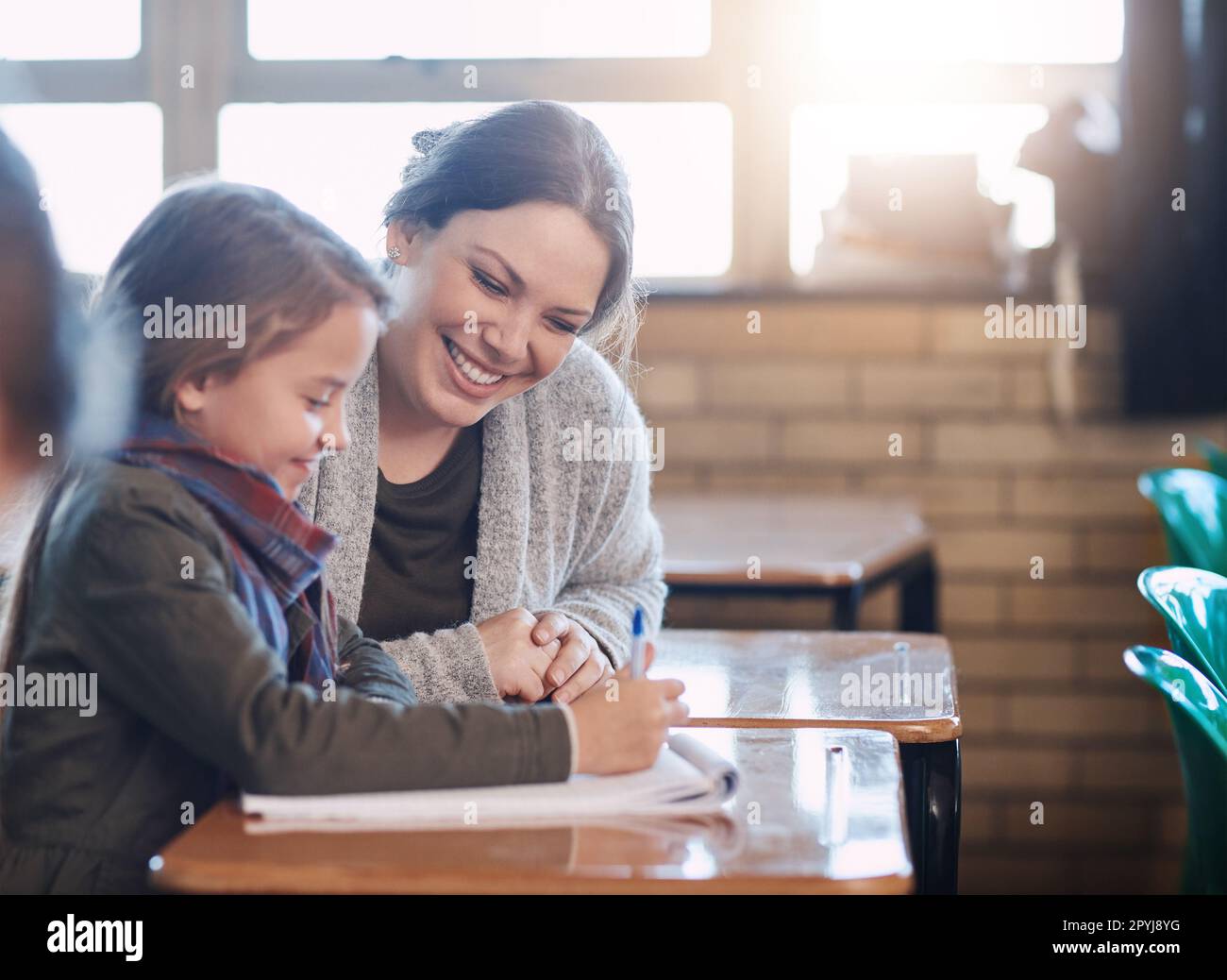 Youre almost there, keep going. an elementary school girl getting help ...