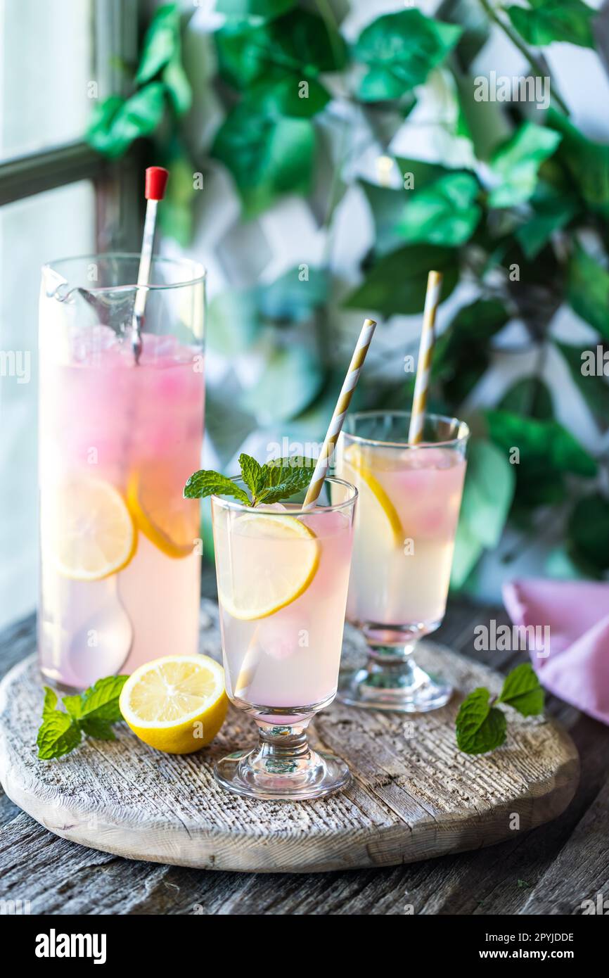 Frosty glasses of cold lemonade with pink lemonade ice cubes. Stock Photo