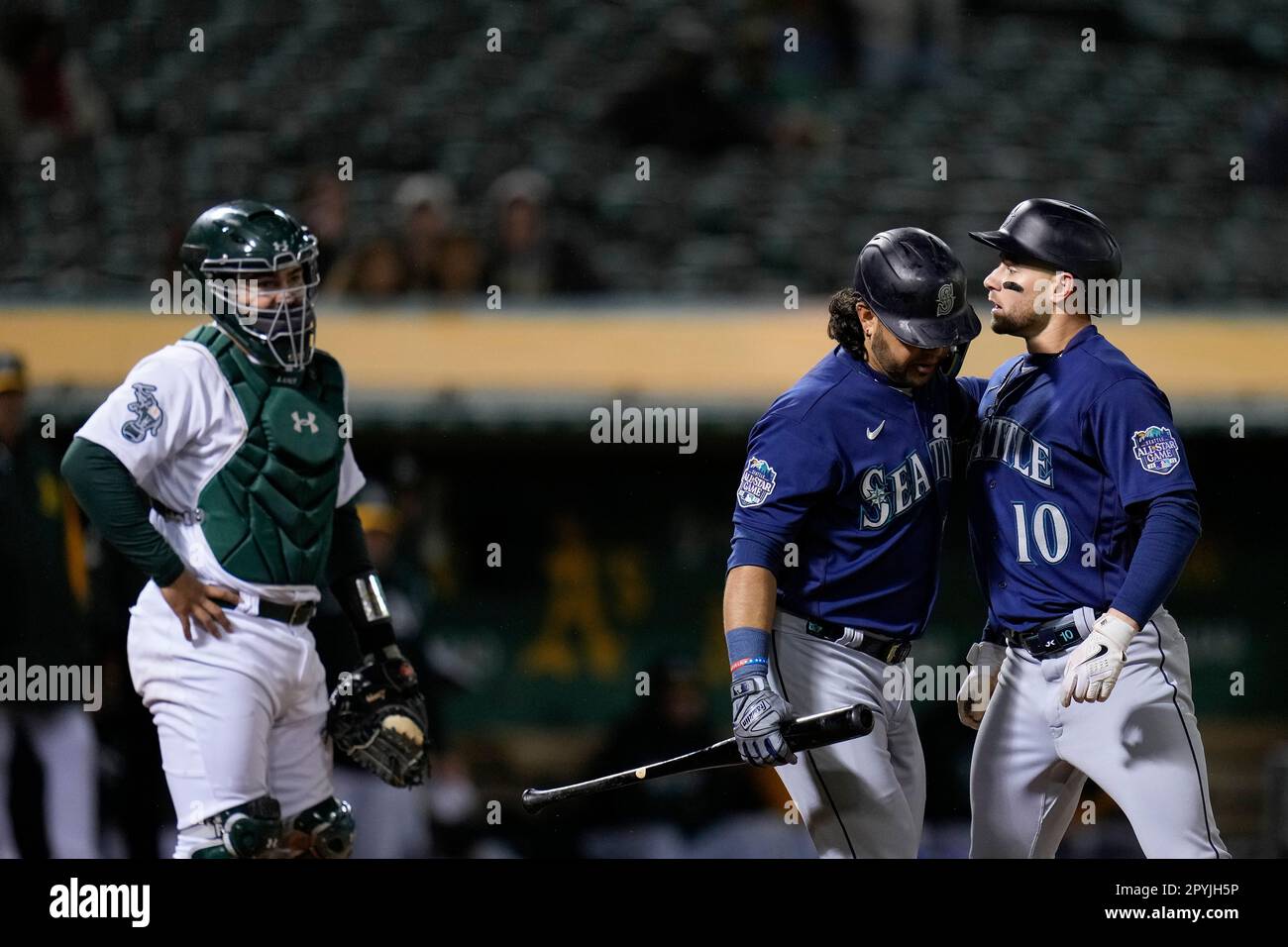 Seattle Mariners' Jarred Kelenic, right, reacts next to Eugenio Suárez after being called out on