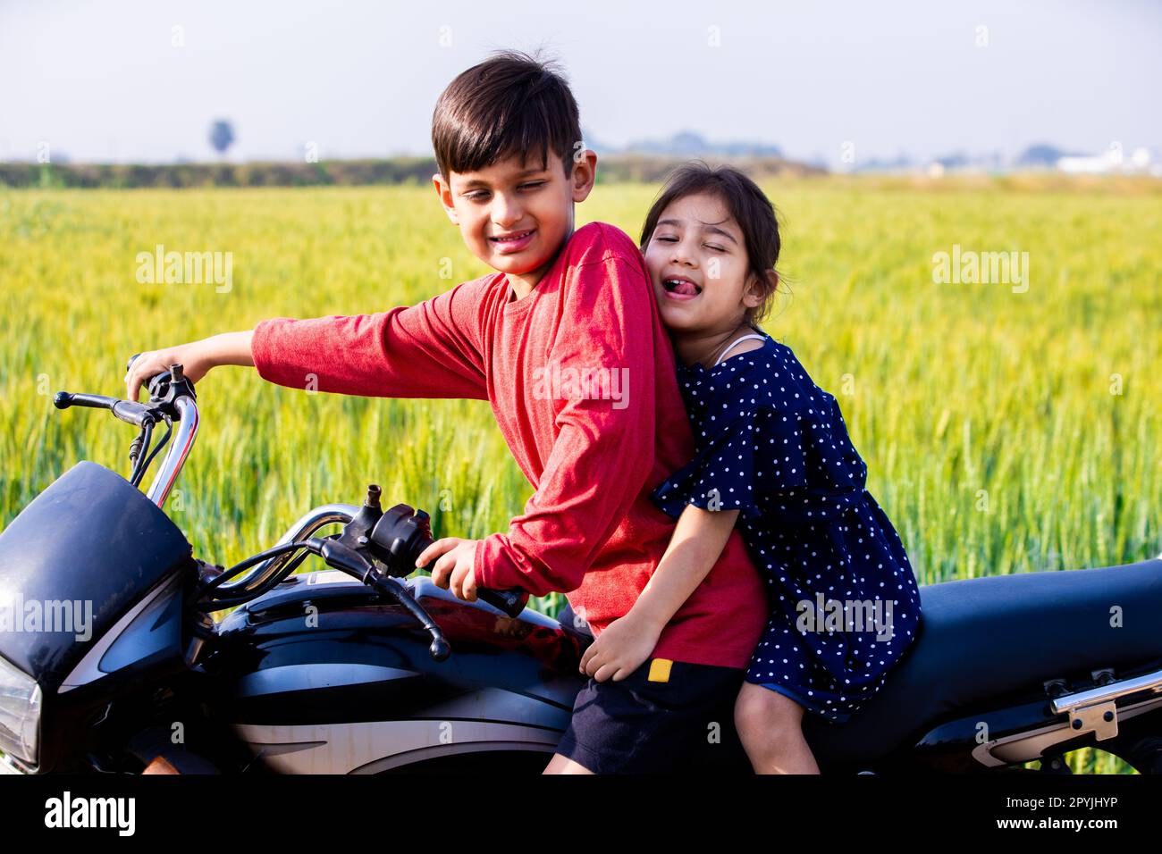 Happy playful children sitting on motorbike or motorcycle together at