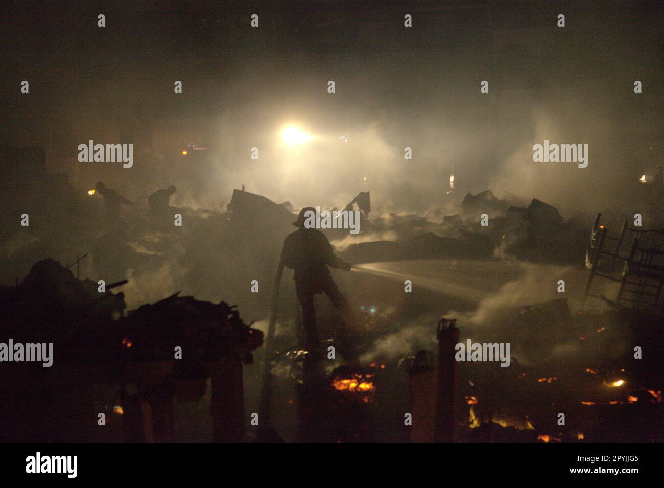 Firefighters performing the cooling phase after a fire accident