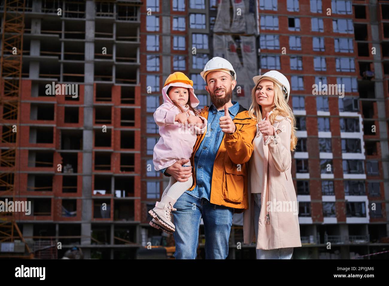 Parents and daughter showing approval gesture and smiling while ...