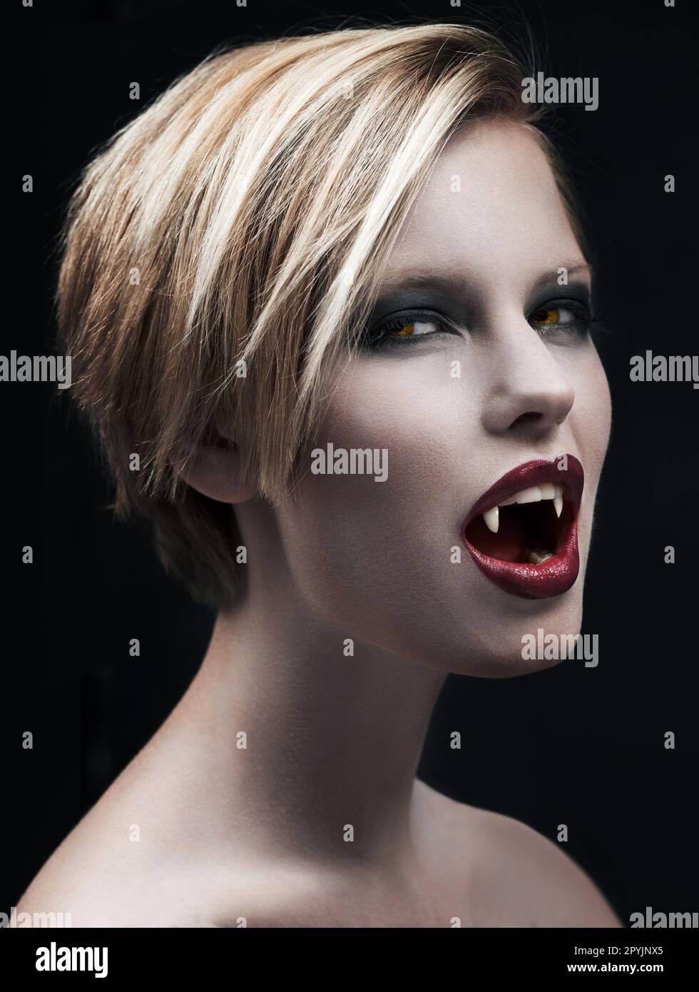 Portrait, fangs and female vampire in studio on dark background for ...