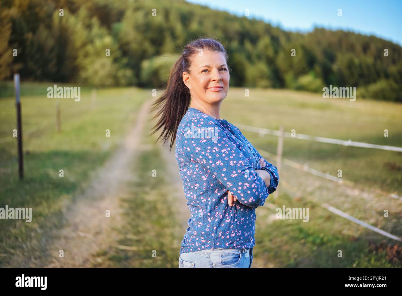 Standing woman in blue shirt hi-res stock photography and images - Alamy