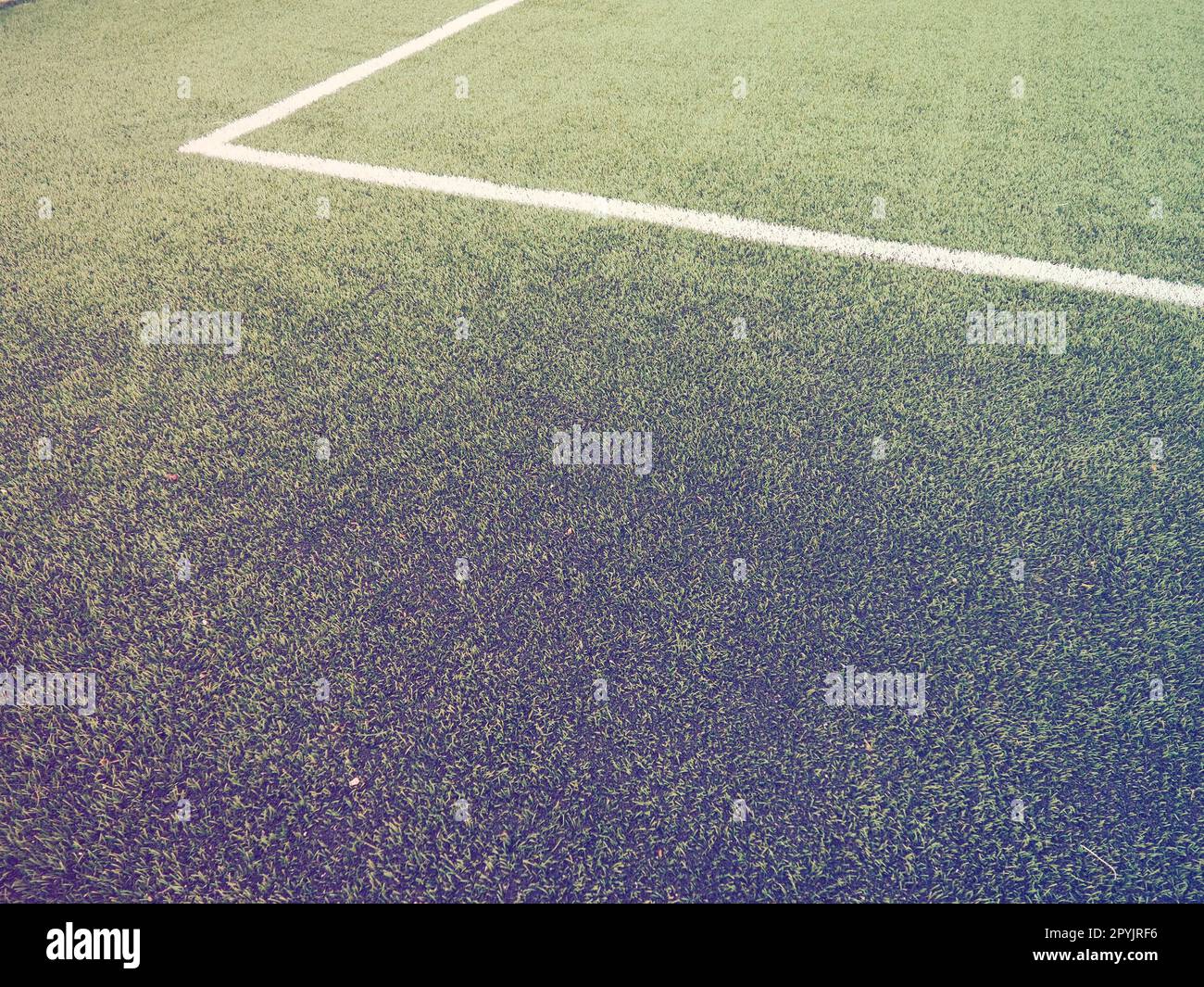 The marking of the football field on the green grass. White lines no more than 12 cm or 5 inches wide. Football field area. Side lines, goal lines. Sun glare. Color and light gradient Stock Photo