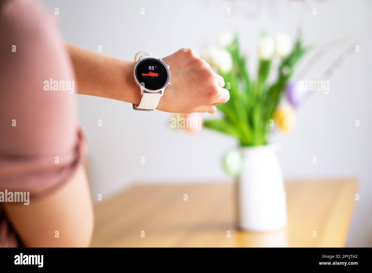 Hand of woman wearing smart watch on the Easter background. Technology, business and people concept. Stock Photo