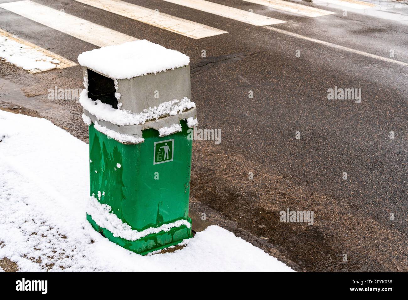 Green metal trash can on the street Stock Photo