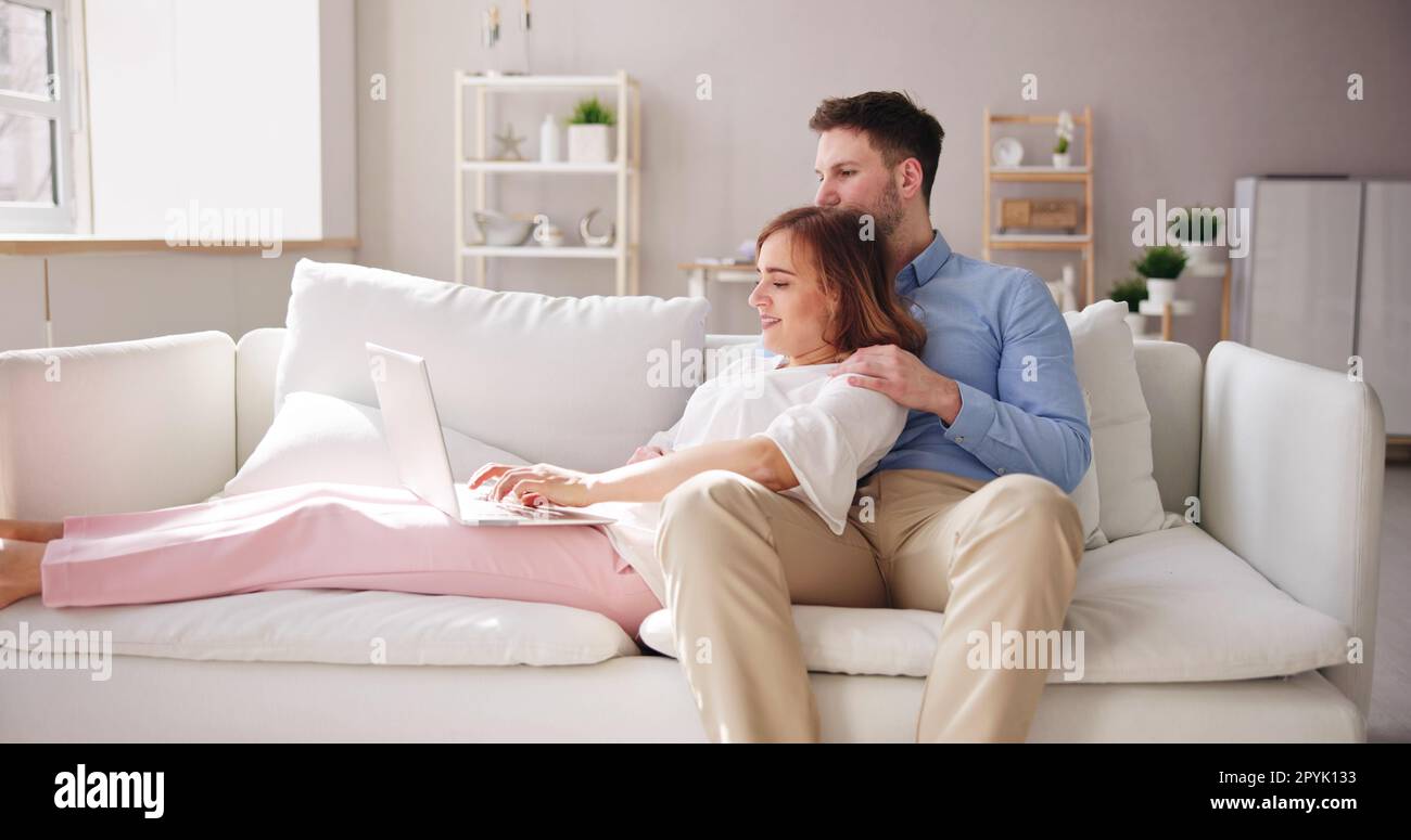 Family Couple Using Laptop And Tablet On Couch Stock Photo