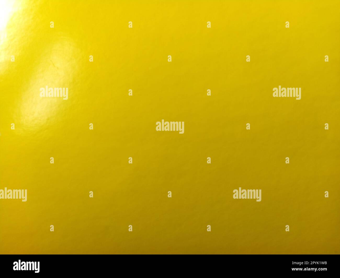 Beautiful bright yellow background. Close-up sheet of shiny reflective incident light paper. Pure fun color. Intense shade of yellow, close to gold or sunny with high reflectivity Stock Photo