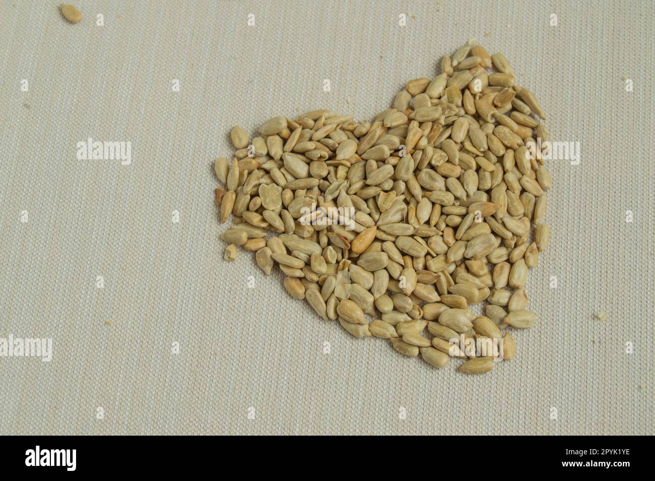 Sunflower seeds scattered on the table in the shape of a heart, the