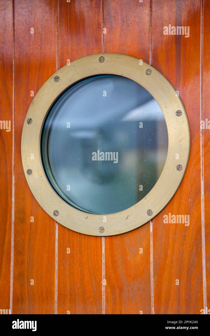 A porthole on a door on a ship. Stock Photo