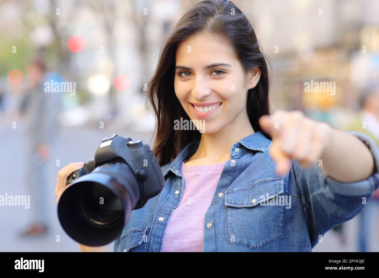 Happy photographer pointing at camera Stock Photo