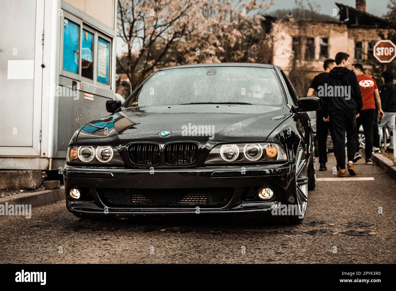 A sleek black BMW car parked in Tuzla on a street in the rain Stock ...