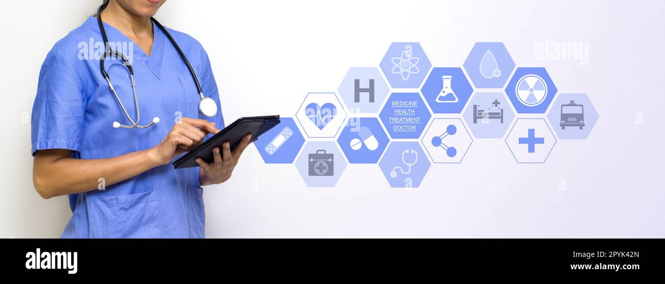 Woman physical therapist in blue uniform holding tablet computer with research icons in modern interface showing symbol of medicine innovation, treatment, discovery and healthcare analysis. Stock Photo