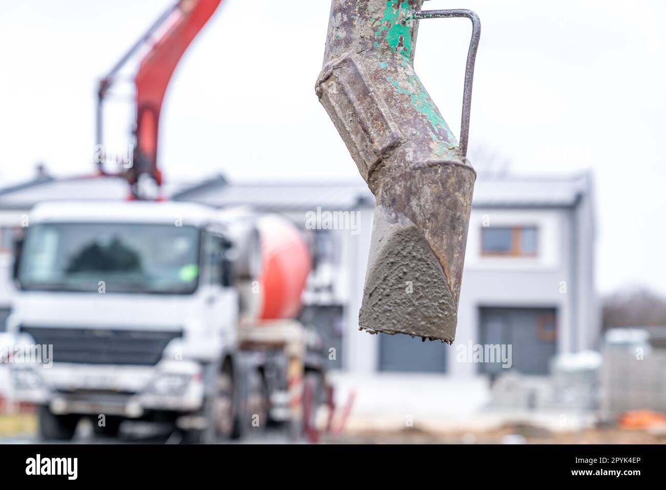 pouring concrete from a mixer truck with a hose into the foundation of
