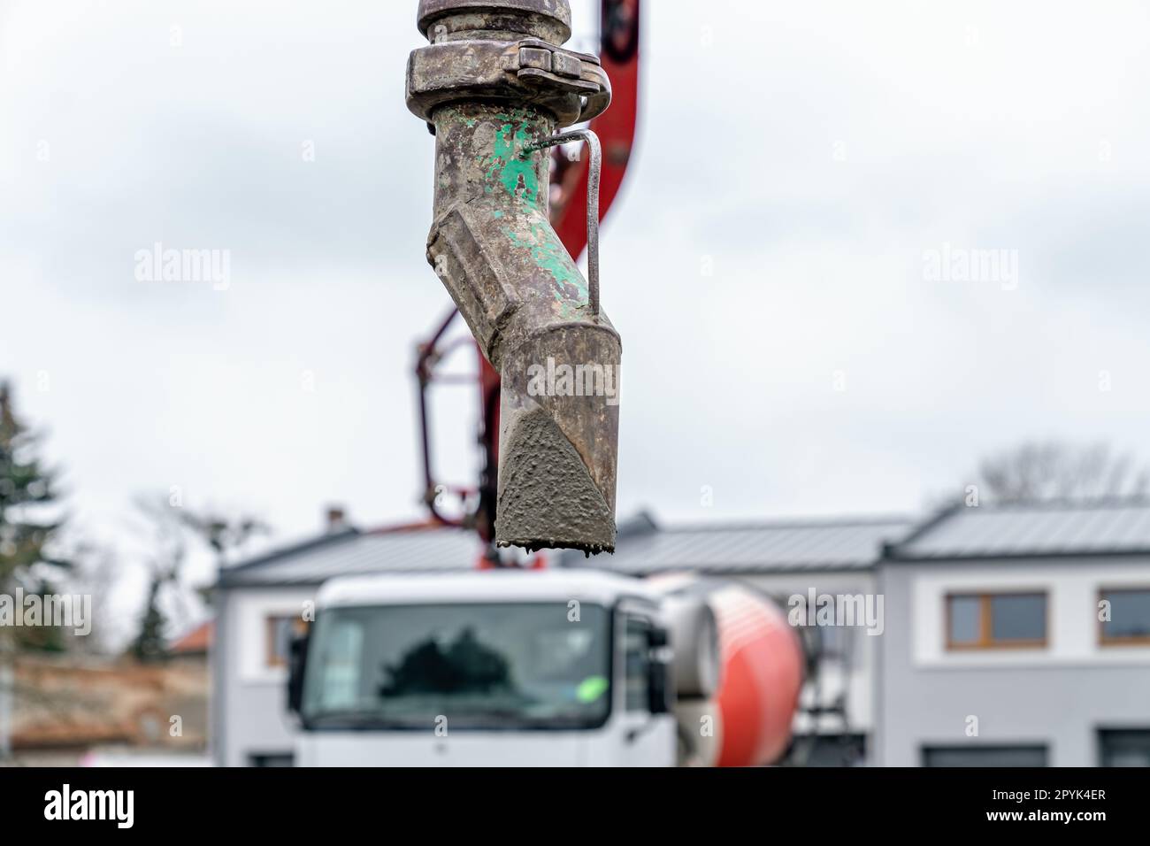 pouring concrete from a mixer truck with a hose into the foundation of