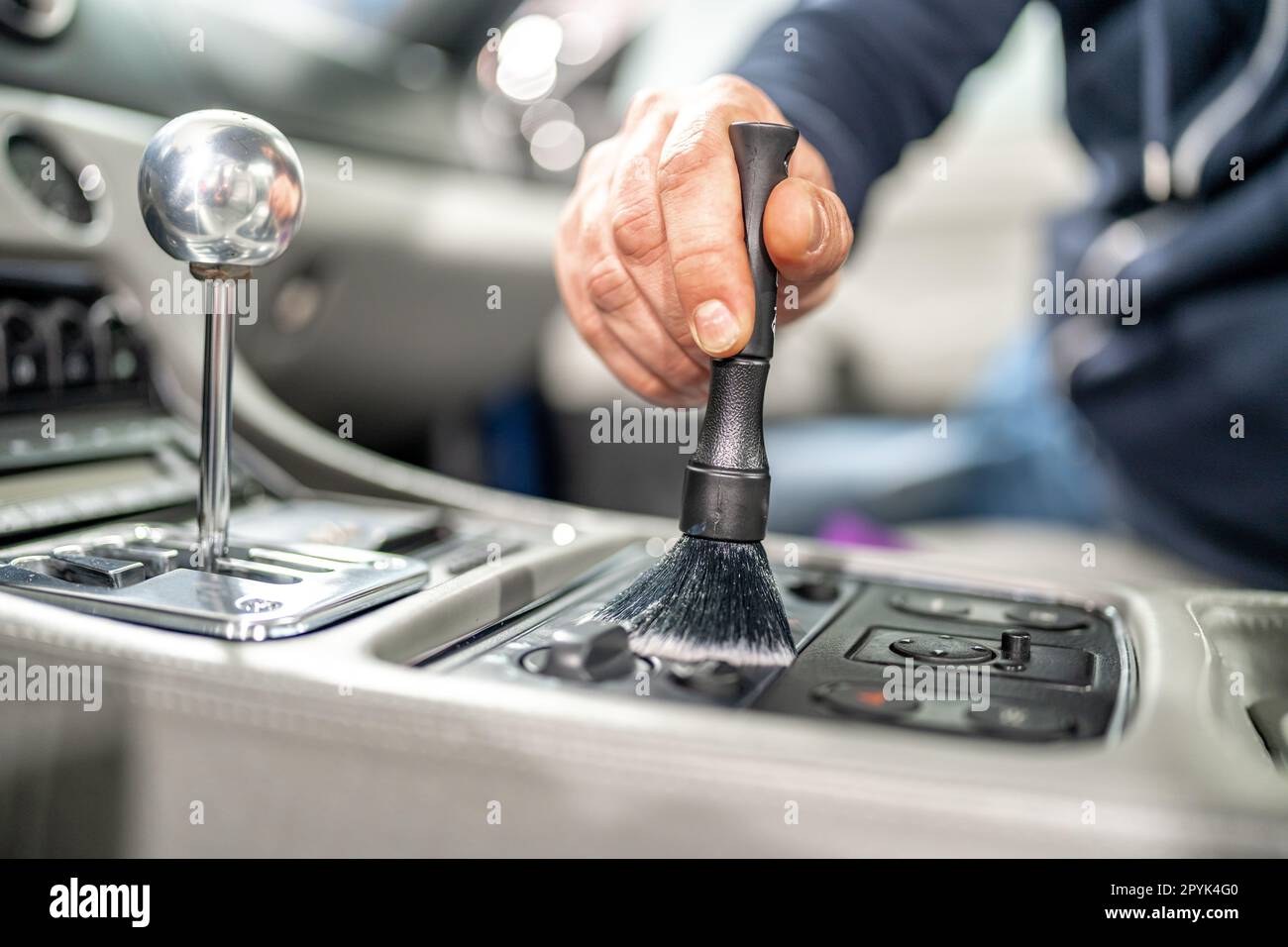 cleaning the interior of a luxury car with a brush Stock Photo Alamy