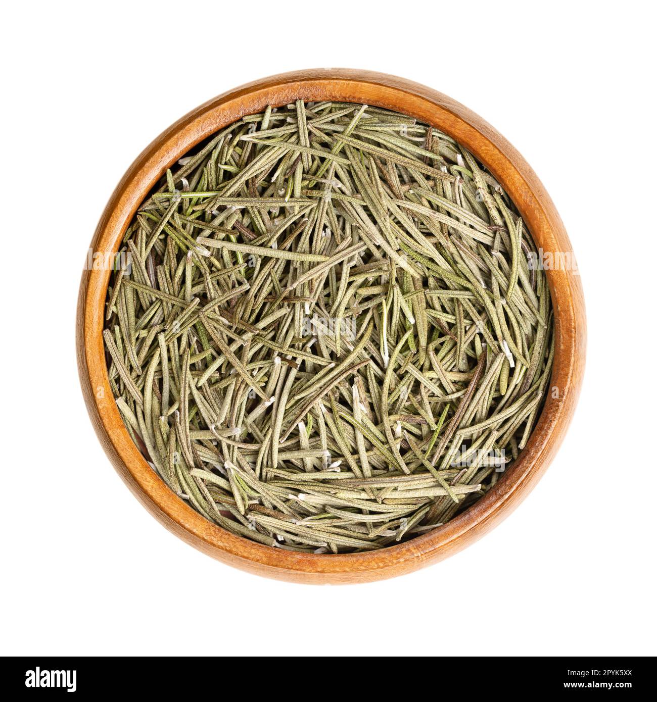 Dried rosemary leaves, fragrant needle-like green leaves, in wooden bowl Stock Photo