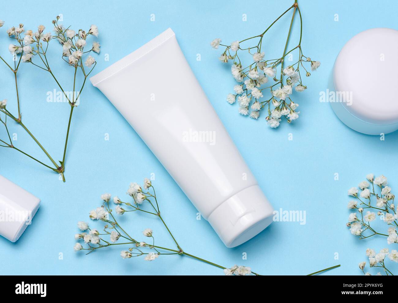 White plastic tube on a blue background, container for cosmetics Stock Photo