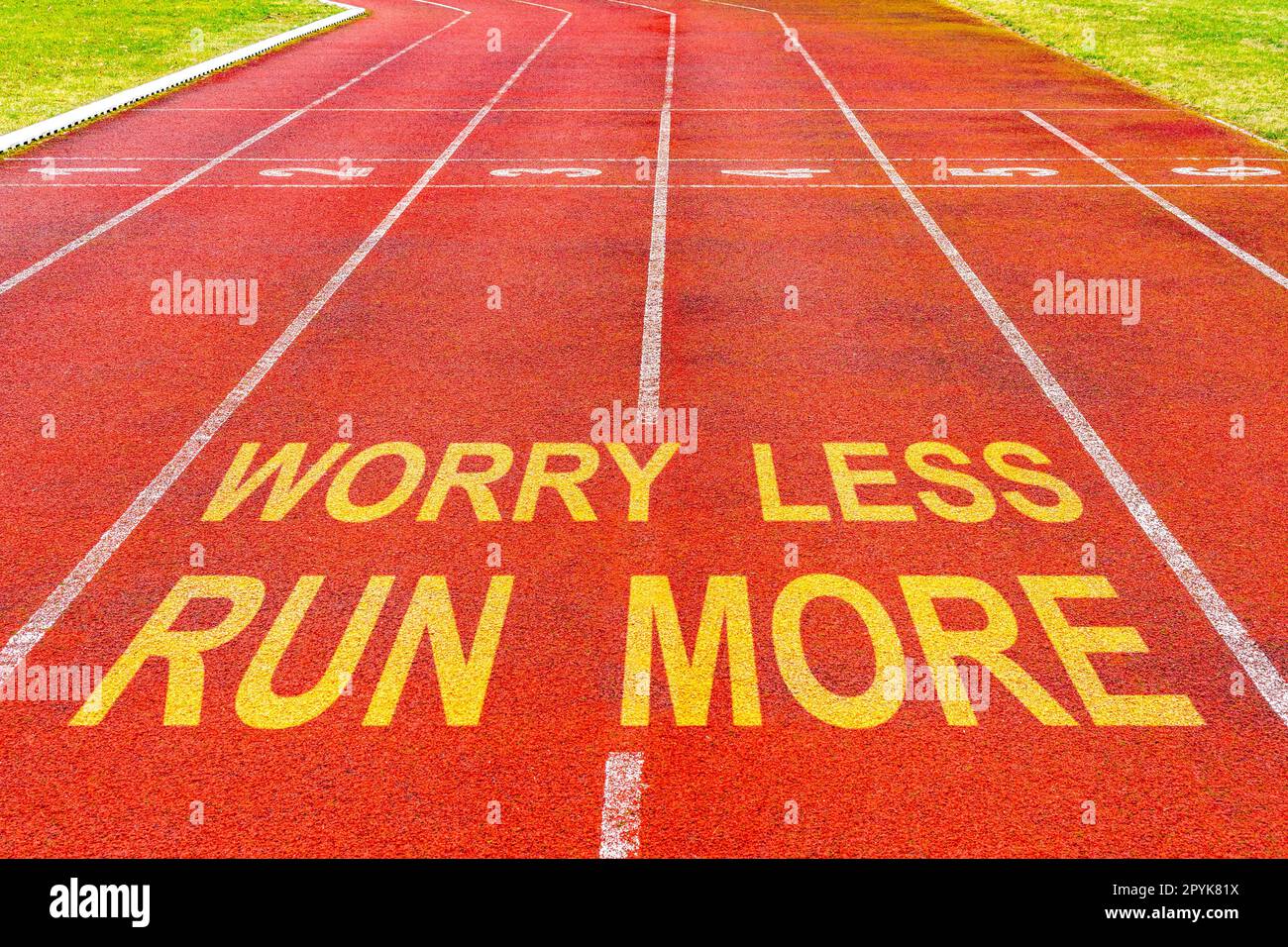 Worry Less Run More written on rubberized running track Stock Photo