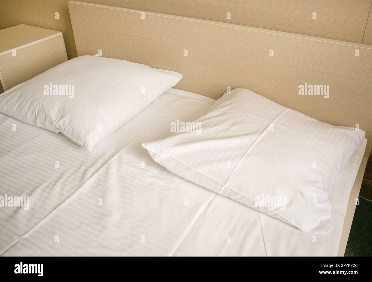 Closeup of white sheets and pillow in a hotel room, modern interior
