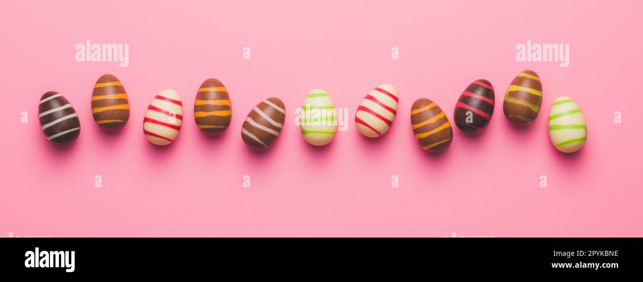 Chocolate easter eggs on pink background. Top view. Stock Photo